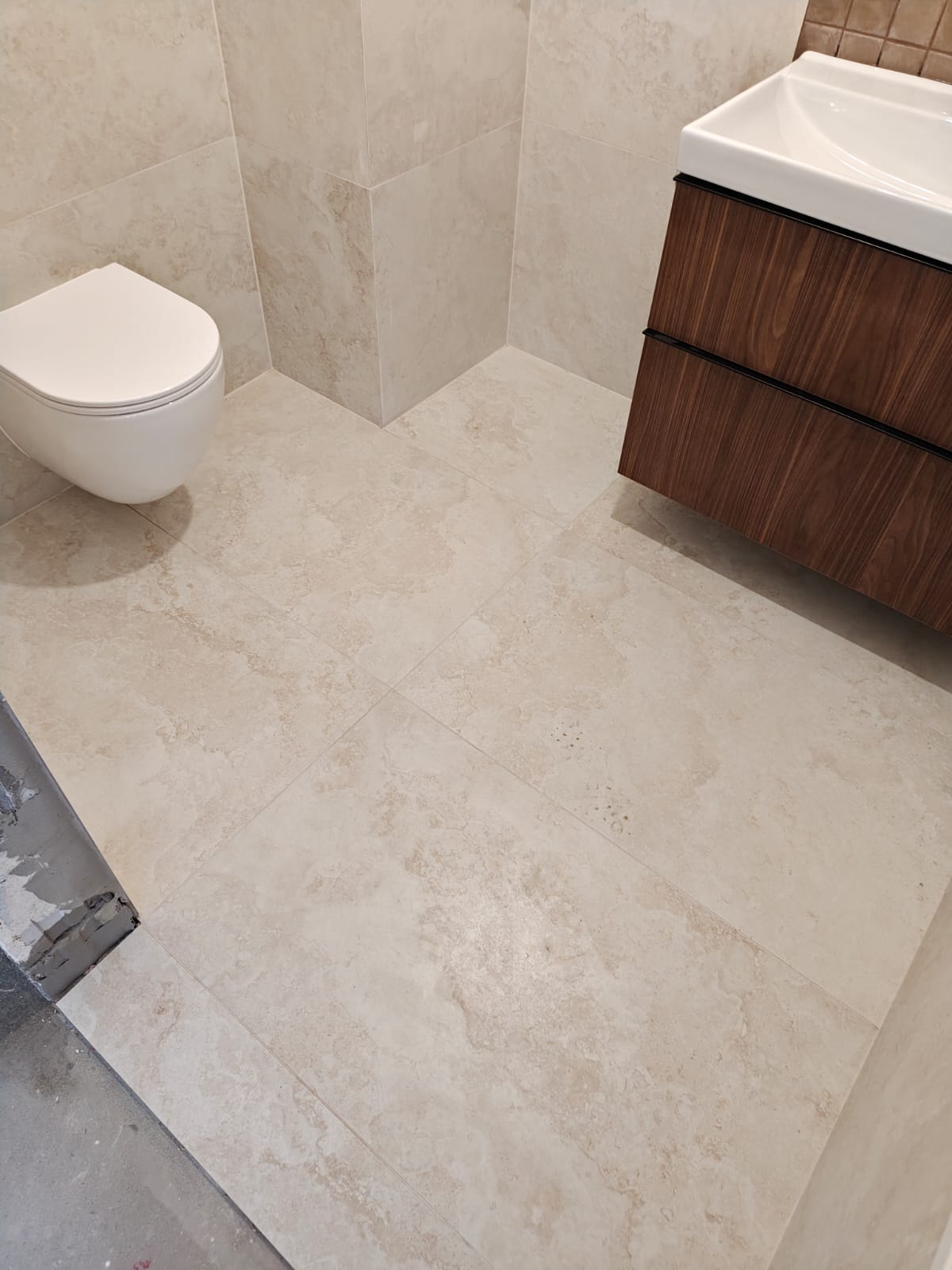 Remont łazienki, realizacja AquaMaster — wielkoformatowa podłoga, wiszące WC i szafka pod umywalkę