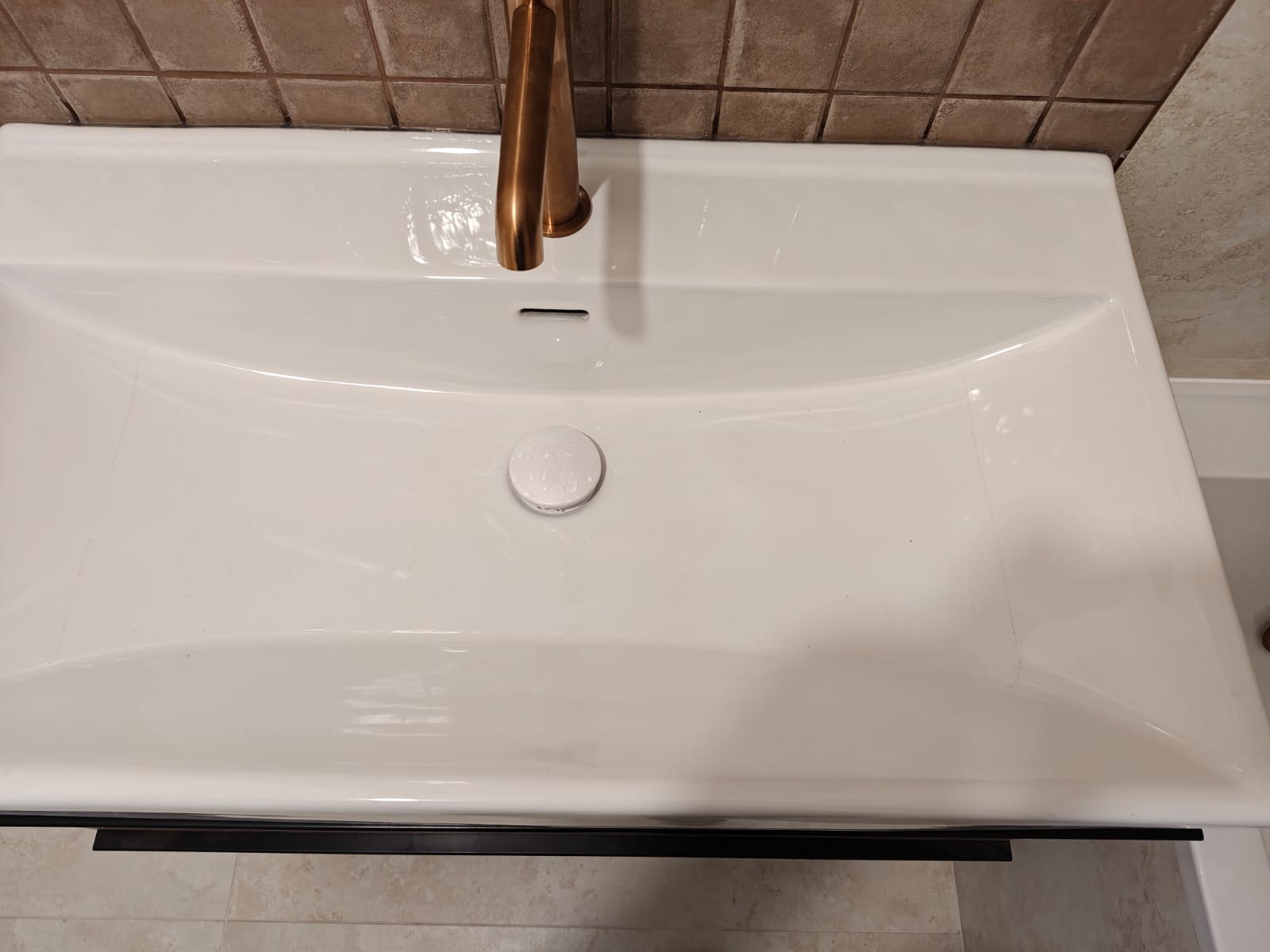 Remont łazienki, realizacja AquaMaster — umywalka z miedzianą baterią — detal