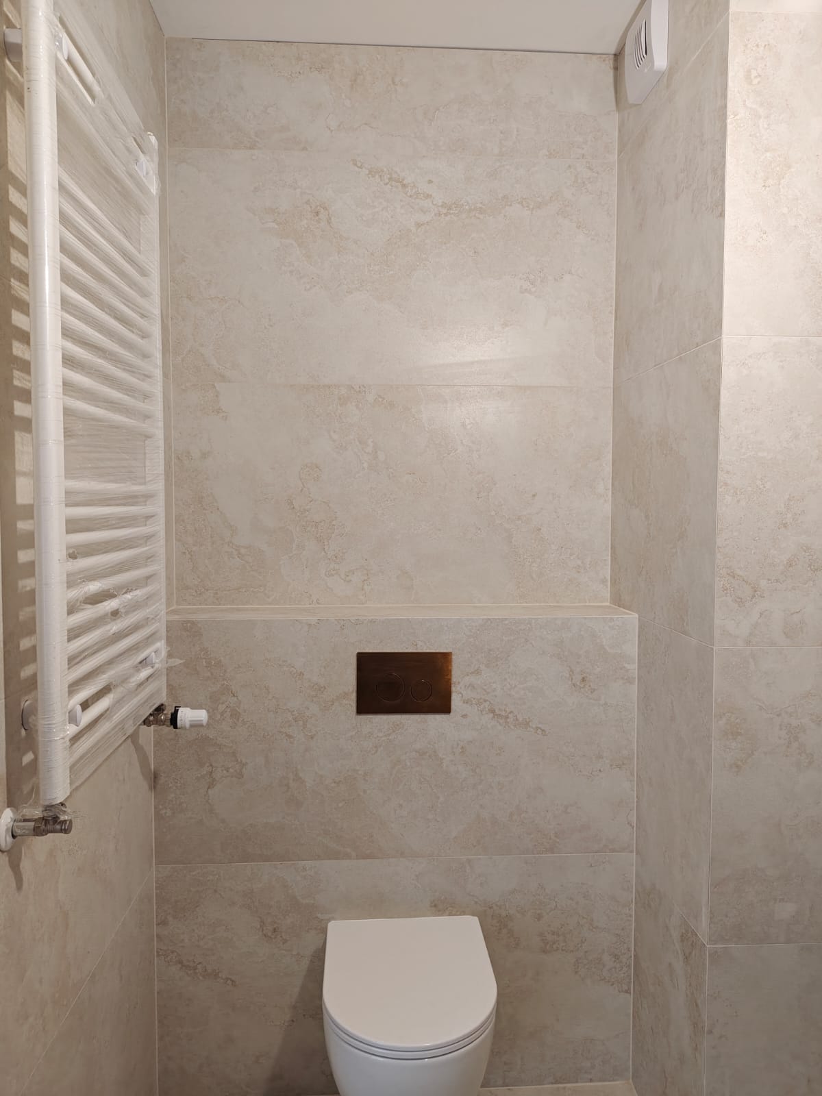 Remont łazienki, realizacja AquaMaster — wiszące WC i grzejnik drabinkowy